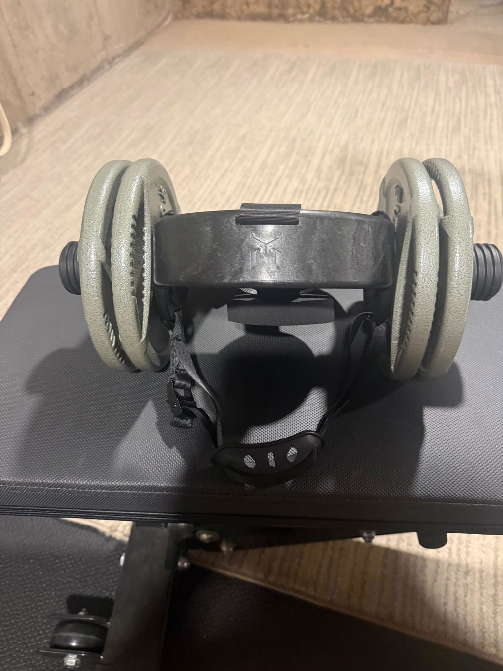 Plate-loaded neck harness resting on a weight bench
