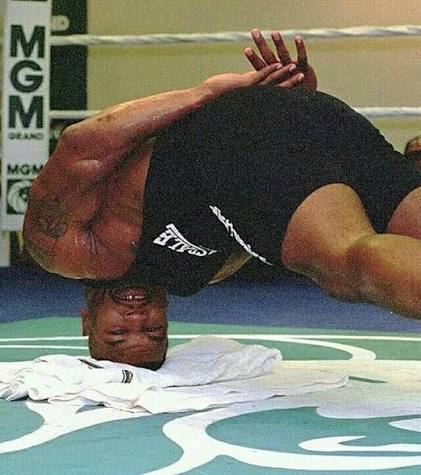 Mike Tyson performing a neck bridge on the gym floor at MGM Grand