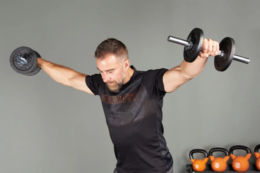 Person doing a lateral raise with spin-lock adjustable dumbbells